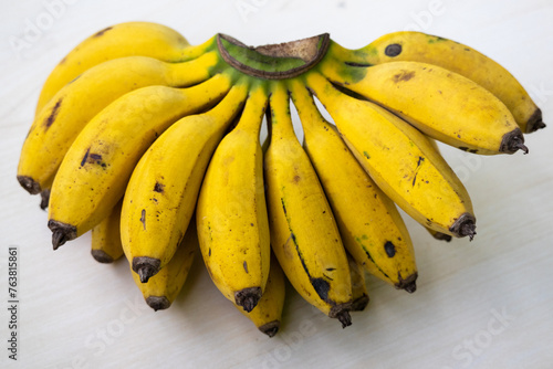 A bunch of fresh ripe yellow bananas on a wooden background. Bananas are healthy fruit. It contains potassium, magnesium, vitamin B6, fiber, tryptophan, and antioxidants.
