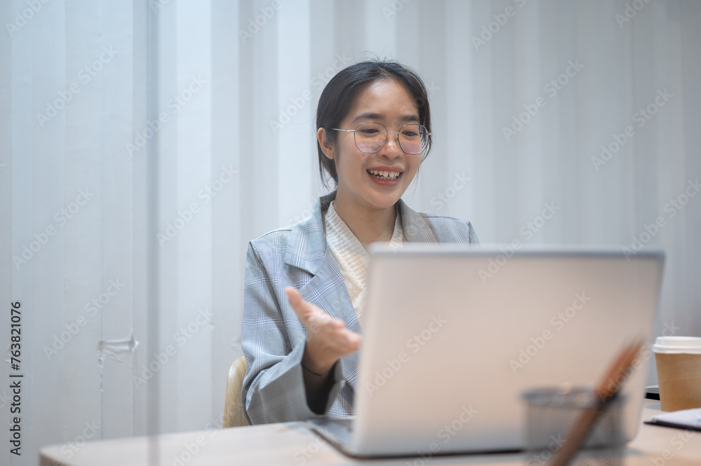 A confident Asian businesswoman is having an online meeting with her client, working in her office. A confident Asian businesswoman is having an online meeting with her client, working in her office.