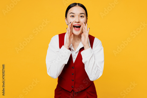 Young corporate lawyer employee business woman of Asian ethnicity wears formal red vest shirt work at office scream share hot news sales discount isolated on plain yellow background. Career concept.