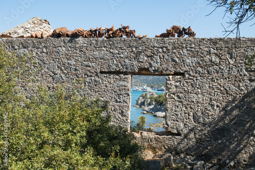 Yachts are seen through castle ruins on the Lycian Way, Üçağız, Turkey photo