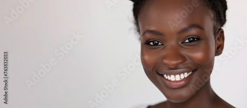 An artistic portrait photography capturing a womans happy smile, emphasizing her eyelashes, ears, and teeth. The fun gesture and laughter are evident against a pure white background