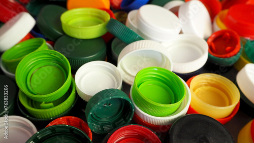 there are many small colorful bottle caps nearby. side view . plastic recycling