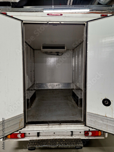 interior refrigerated truck is insulated and hygienically white for transporting goods and refrigerated food, meat, for kitchen operations. rental of delivery van, shipment, service, open door, dock photo