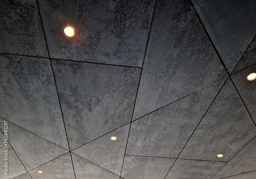 soffit ceiling with spotlights. irregular geometrical division by joints. cement look. backlit garage interior photo