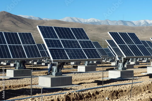 A row of solar panels are lined up on a hillside photo
