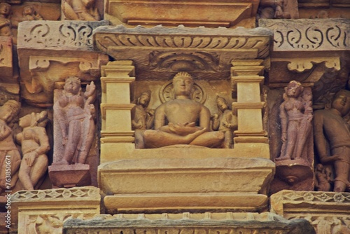 A finely detailed stone sculpture of a Jain Tirthankara ADINATH, with a serene expression, surrounded by ornate carvings photo