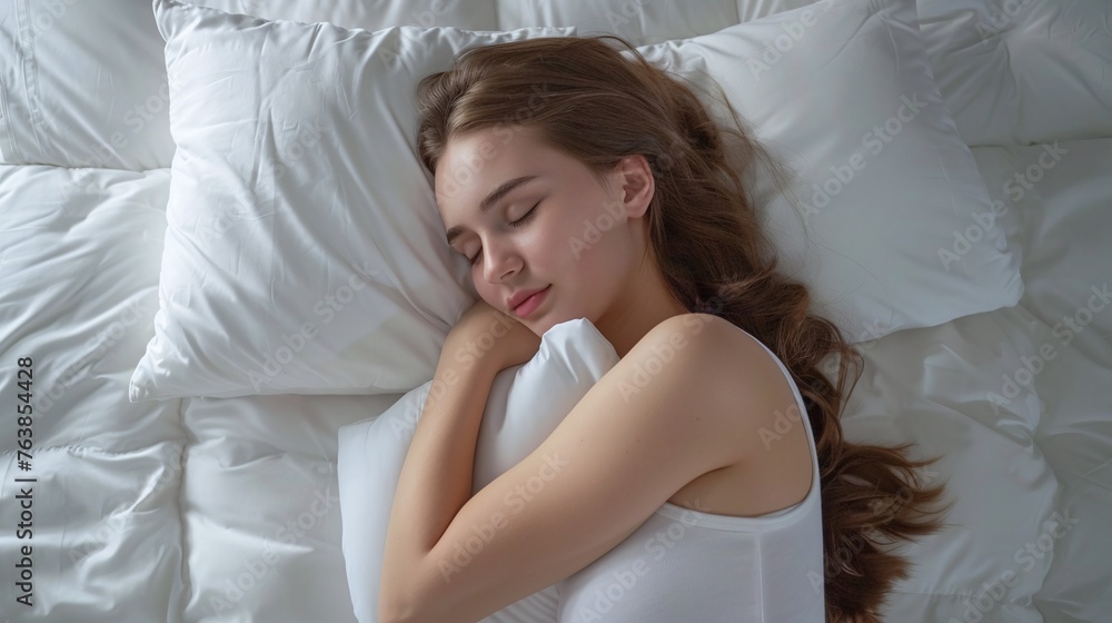 top view of teenage girl sleeping soundly in bed, hugging soft pillow for good night sleep concept top view of teenage girl sleeping soundly in bed, hugging soft pillow for good night sleep concept