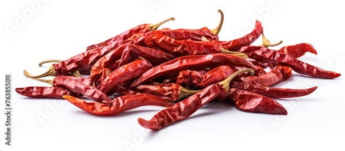 A close up of a pile of red chili peppers on a white surface