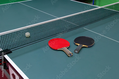 Table tennis ball and two rackets on the table - stock photo