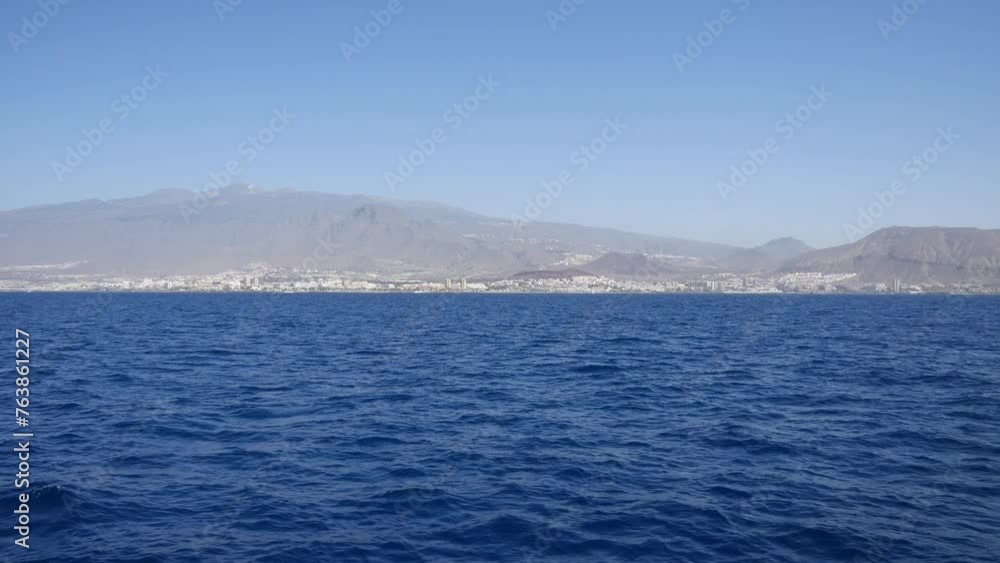 Ocean view with mountainous coastline in the distance, clear blue sky. Scenic seascape, travel destination, coastal cityscape in Tenerife canary islands Ocean view with mountainous coastline in the distance, clear blue sky. Scenic seascape, travel destination, coastal cityscape in Tenerife canary islands