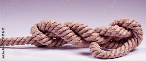 The rope knot is isolated on a white background as a strong nautical line tied together as a symbol of trust and faith and a metaphor for strength or tension colorful background