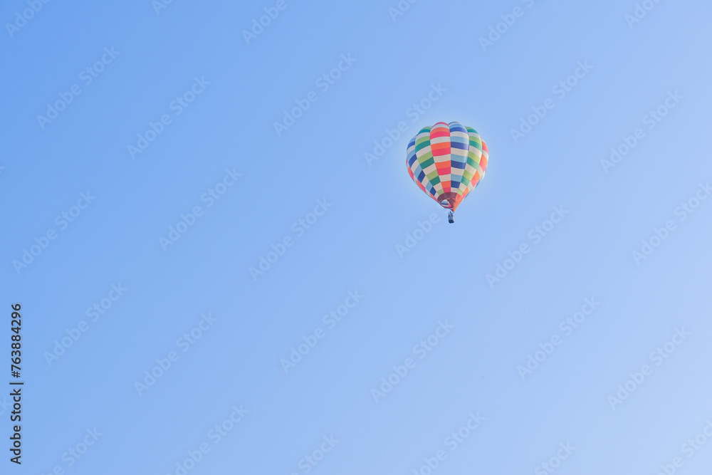 Hot air balloons landing in a mountain flight over field and forest,colorful Hot air balloons flying over the valley with blue sky,Tourism concept. Hot air balloons landing in a mountain flight over field and forest,colorful Hot air balloons flying over the valley with blue sky,Tourism concept.