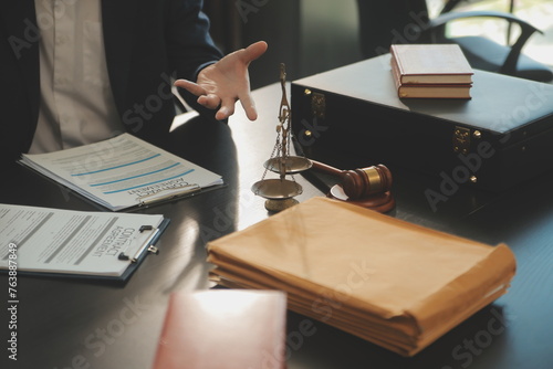 Pojęcie sprawiedliwości i prawa. Radca prawny przedstawia klientowi podpisaną umowę z młotkiem i prawem lub organizuje spotkanie prawne w kancelarii prawnej w tle