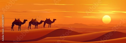 Camel stands on the top of dunes in the desert at sunset.