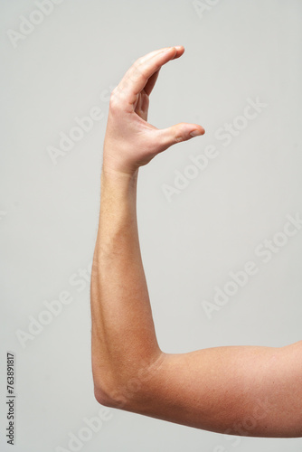 Male hand gestures over gray background studio shot