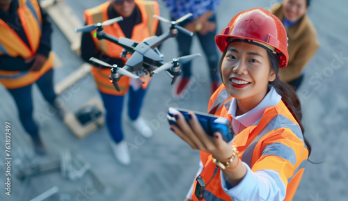 Construction workers in hard hats smile as woman holds electric blue drone
