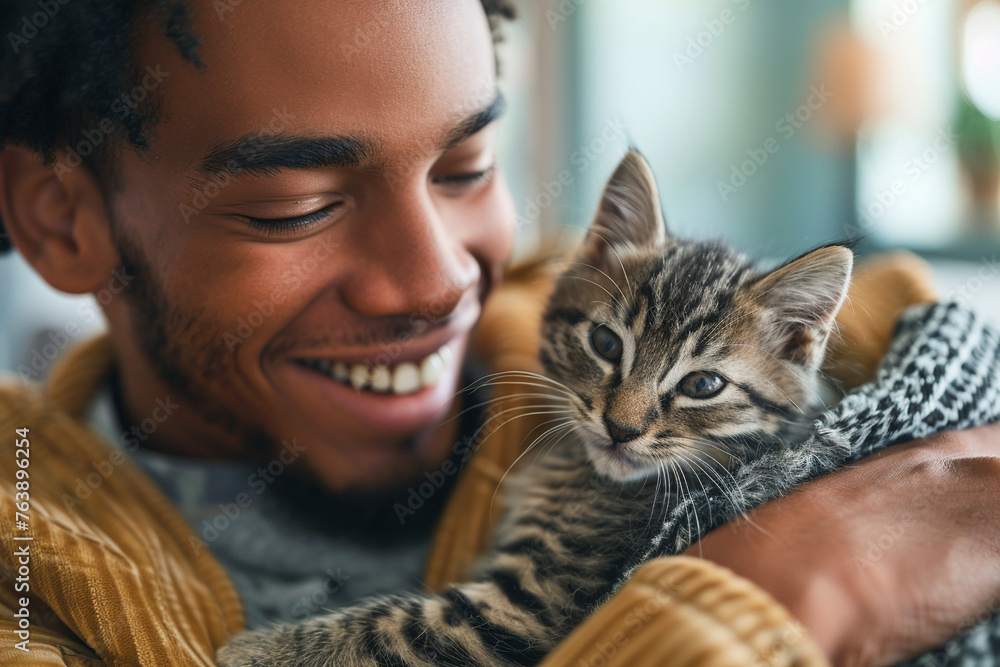 Joyful playtime, diverse male sitter with a kitten, living room, action shot, natural expression, clean, modern setting Joyful playtime, diverse male sitter with a kitten, living room, action shot, natural expression, clean, modern setting