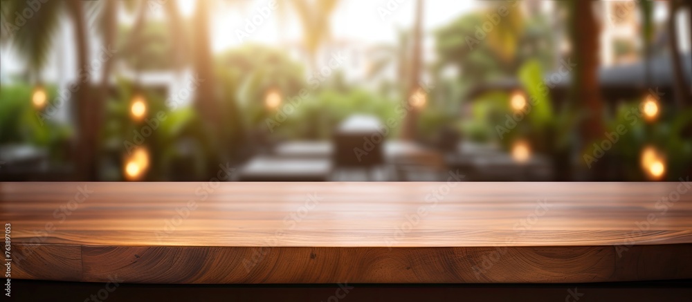 A wooden table surface with a defocused view of gentle lights in the distance A wooden table surface with a defocused view of gentle lights in the distance