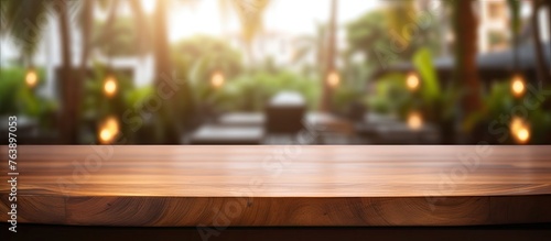 A wooden table surface with a defocused view of gentle lights in the distance