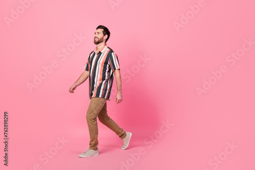 Full body length size photo of optimistic young smiling man steps looking empty space black friday isolated over pink color background