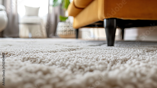 A close up of a carpeted floor with a yellow couch in the background