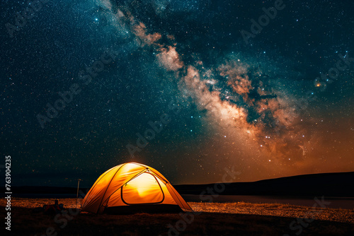 milky way across the entire sky, a small illuminated tent on the ground, night sky full of stars