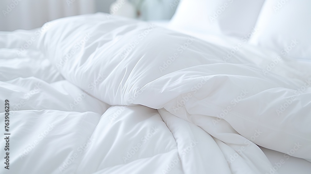 White folded duvet lying on white bed background. Preparing for winter season, household, domestic activities, hotel or home textile White folded duvet lying on white bed background. Preparing for winter season, household, domestic activities, hotel or home textile