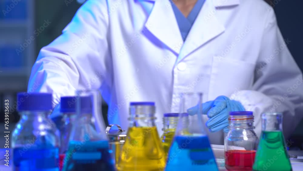 Life scientists researching in laboratory. Focused female life science professional pipetting solution into the glass cuvette. Healthcare and biotechnology concept. Life scientists researching in laboratory. Focused female life science professional pipetting solution into the glass cuvette. Healthcare and biotechnology concept.
