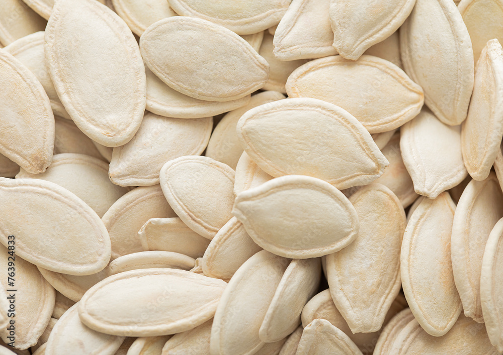 Raw white salted pumpkin seeds top view macro background.Healthy snack. Raw white salted pumpkin seeds top view macro background.Healthy snack.