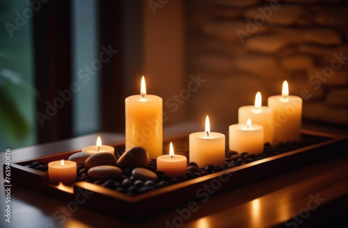 Burning aromatic candles with stones on a wooden tray in a spa salon, relaxing atmosphere.