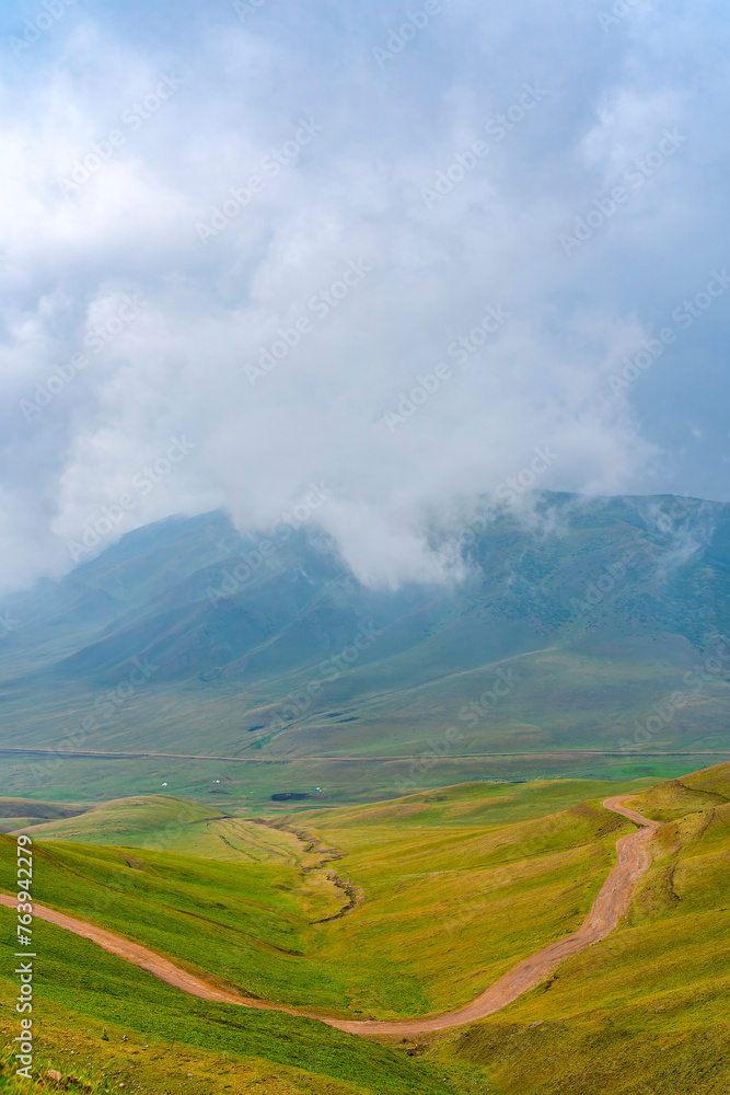 Summer landscape with green hills and cloudy sky. Plateau Assy, Kazakhstan