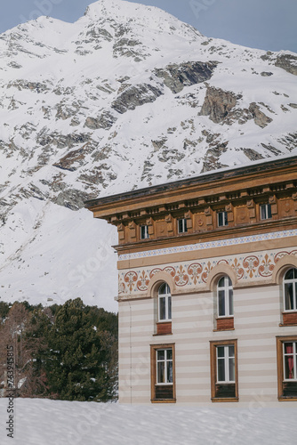 Maloja, Switzerland - March 2024: The architecture of the elegant Maloja Palace Hotel surrounded by snowy mountains