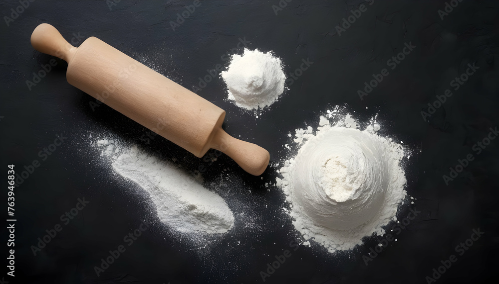Rolling pin and white flour on a dark background. Top view. Rolling pin and white flour on a dark background. Top view.