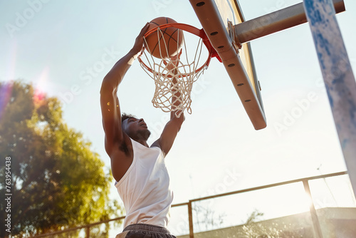 Basketball Player in a White Uniform Jumps High To Make a Slam Dunk to the Basket Outdoor. Basketball Player in Training
