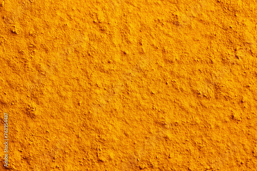 Background made of turmeric root powder, with copy space