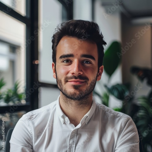 Man in White Shirt Sitting in Front of Window