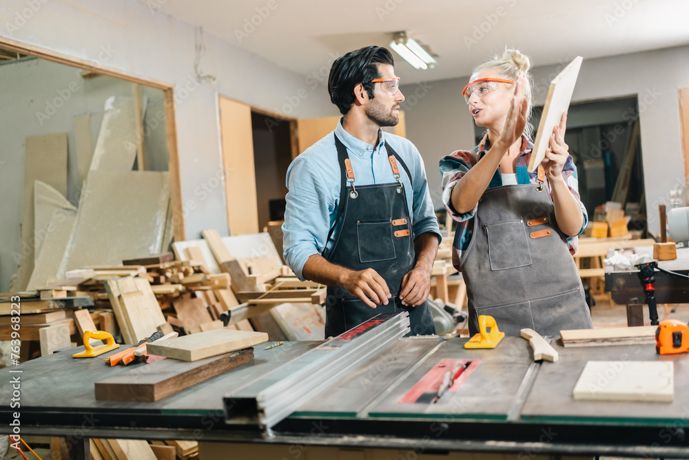 In a carpenter's shop, a skilled man with training in the craft uses tools to perform woodwork, blending occupation, industry, and business. In a carpenter's shop, a skilled man with training in the craft uses tools to perform woodwork, blending occupation, industry, and business.