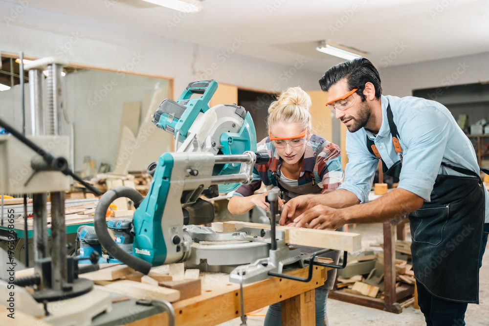 In a carpenter's shop, a skilled man with training in the craft uses tools to perform woodwork, blending occupation, industry, and business. In a carpenter's shop, a skilled man with training in the craft uses tools to perform woodwork, blending occupation, industry, and business.