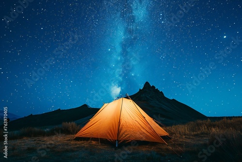 Tourist tent in the mountains at night with starry sky