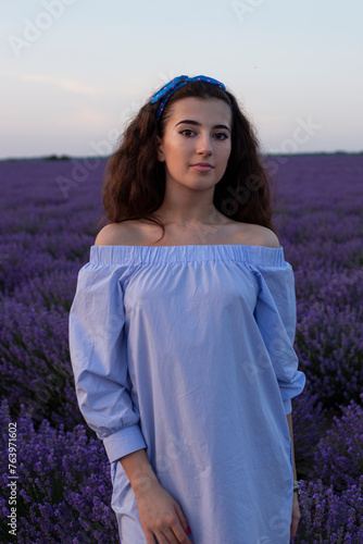 Confedence young brunette girl in summer dress posing in lavender field, beautiful background. photo