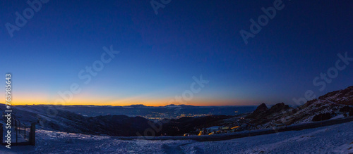 Panoramic view at the city of Granada during evening twilight after sunset seen from Sierra Nevada mountains  Andalusia  Spain