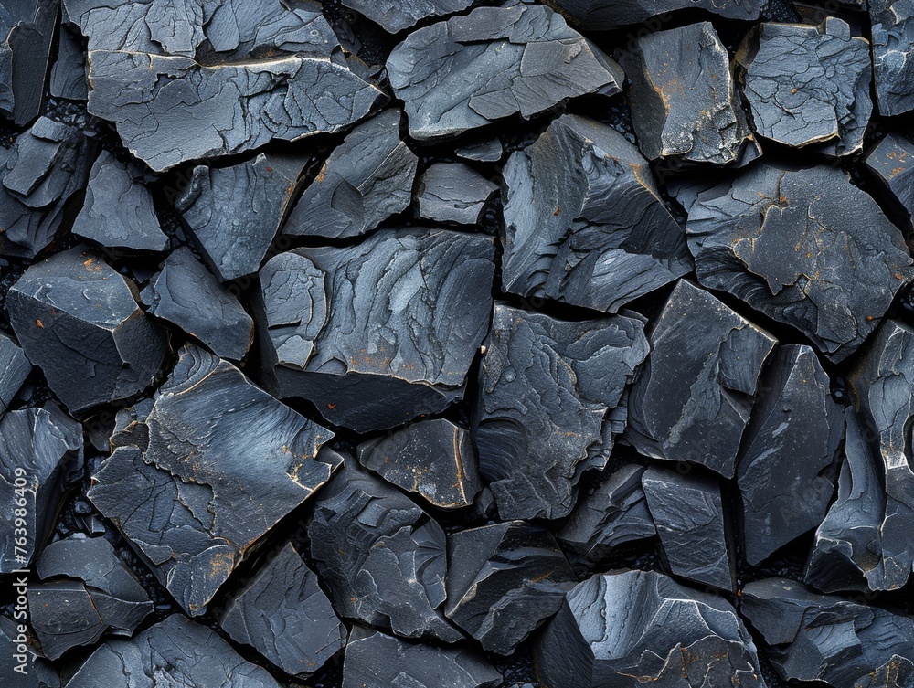 A close up of a black rock wall with a rough texture A close up of a black rock wall with a rough texture
