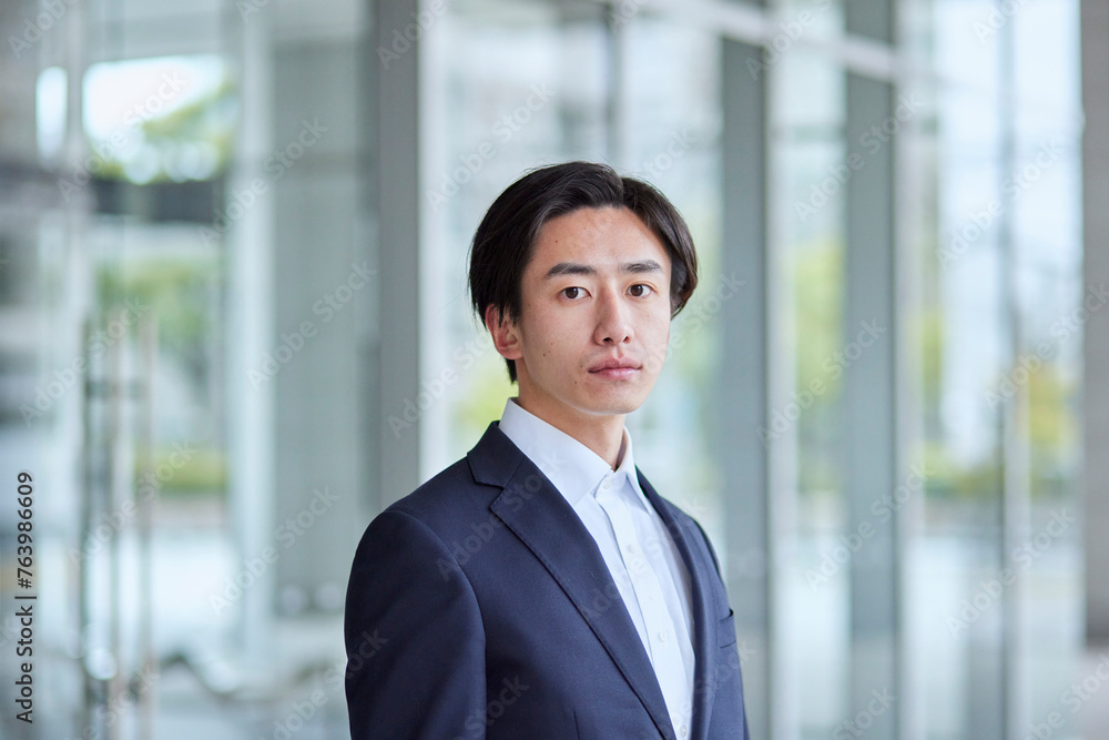 オフィスビルとスーツを着た若い日本人ビジネスマン オフィスビルとスーツを着た若い日本人ビジネスマン