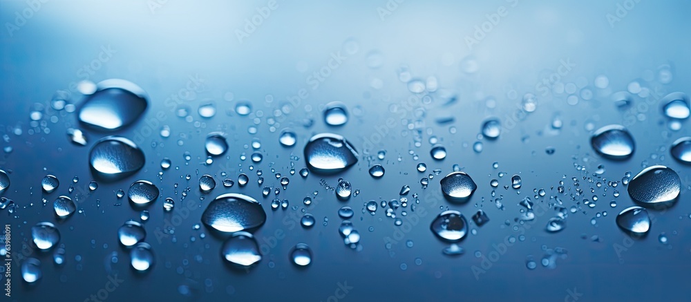An up-close view of small water droplets collecting on the smooth surface of a window