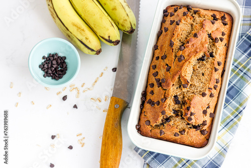 Banana Oatmeal Healthy Bread with Chocolate Chips in a Baking Tin Top Down Vertical Photo on White Background