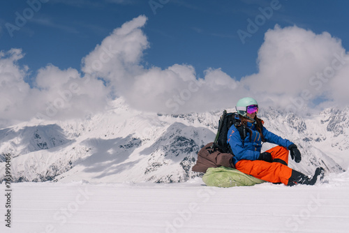 Woman freerider snowboarder sitting on the slope relaxing while skiing off piste