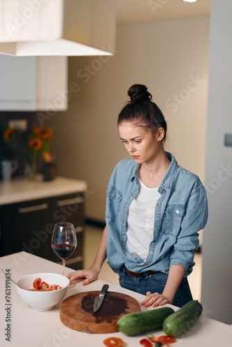 Alone in the Kitchen: A Young Woman Enjoying a Gourmet Meal and a Glass of Wine in a Modern, Elegant Interior