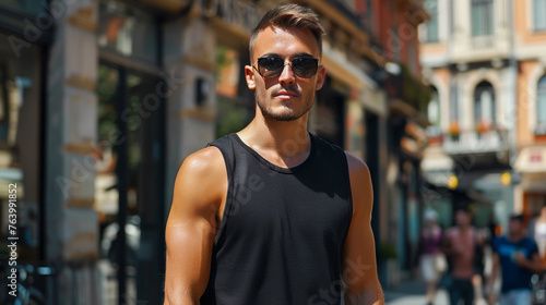 Attractive young man wearing blank empty black tank top mockup for design template in the city street
