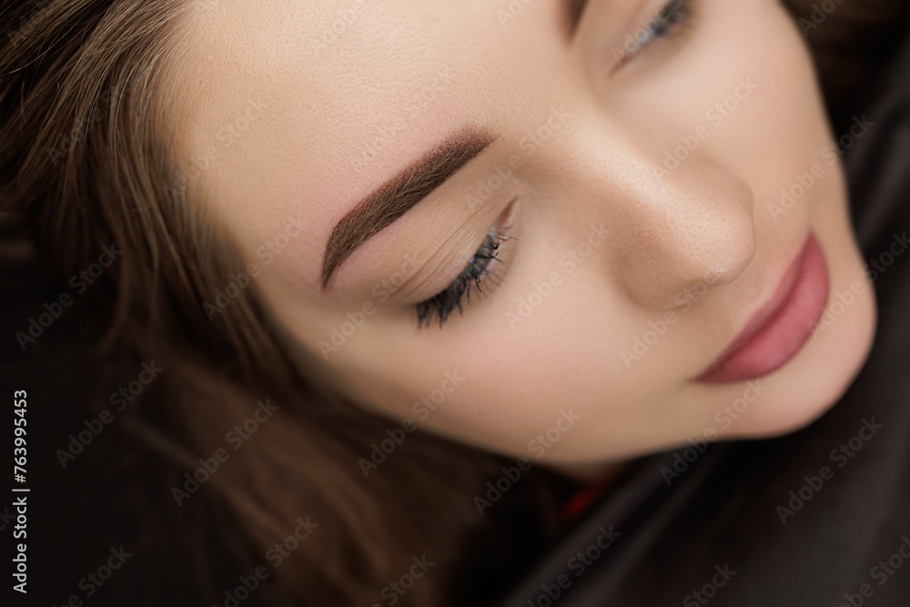 Obraz premium Beautiful permanent makeup after the second procedure of eyebrow correction. Second PMU procedure in a month of permanent eyebrow makeup. Permanent makeup correction.