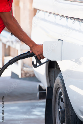 Canvas Print Gas pump nozzle in the fuel tank of a bronze car, refuel